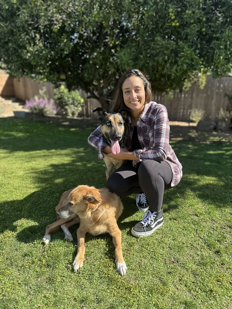 Miriam M. Shanaman, VMD, MS, DACVR, Chief Medical Officer and Co-Founder of RadsForVets, outdoors with her two dogs